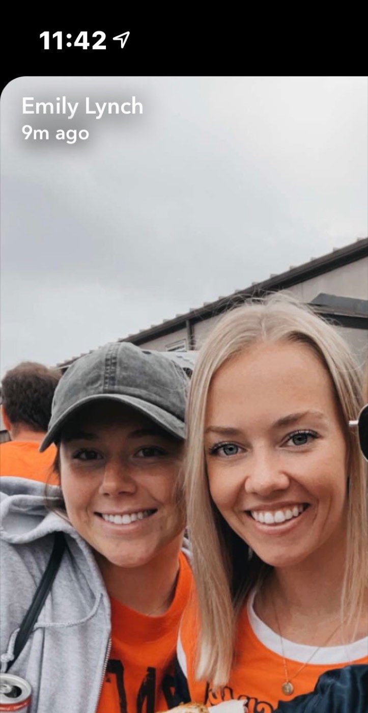 Two friends in orange at a tailgate